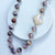 faceted milky white chalcedony clover quadrafoil pendant on botswana agate bead necklace